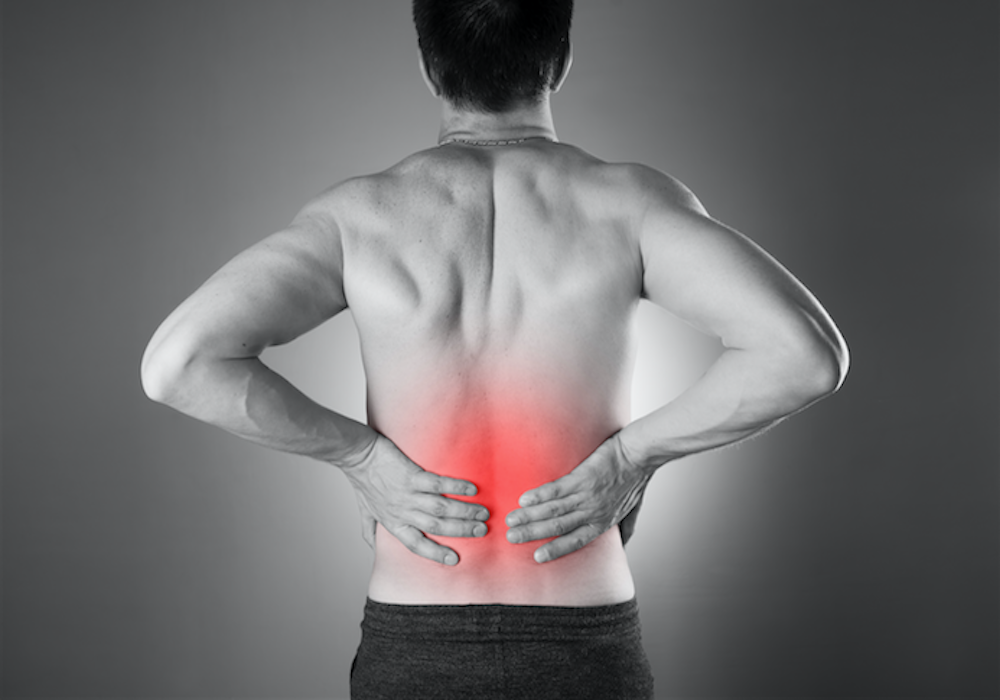 Man holding his lower back, with the painful area highlighted